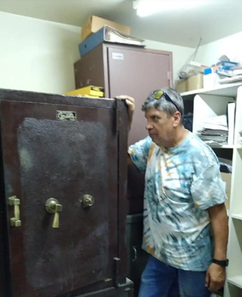 Técnico junto a caja fuerte antigua durante reubicación de bóveda empresarial en cambio de oficina