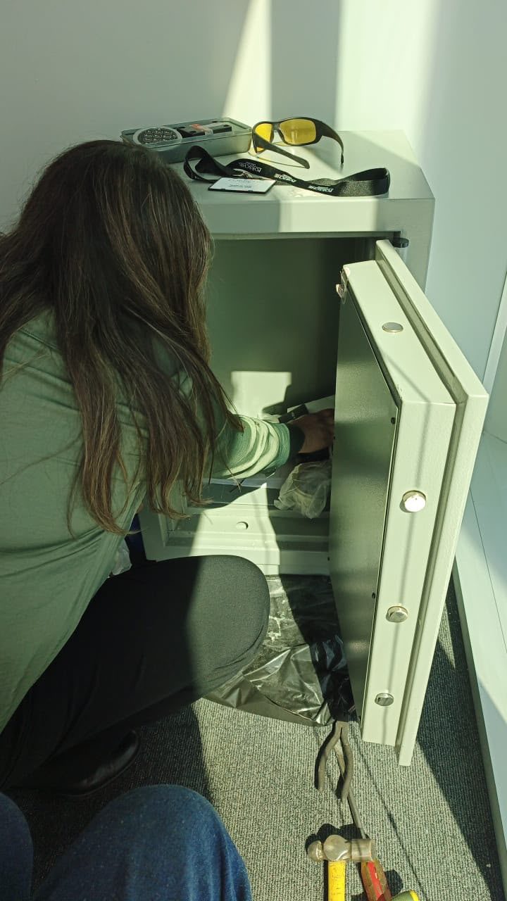 Caja fuerte gris abierta en una oficina de Las Condes, con el teclado electrónico desmontado sobre la caja