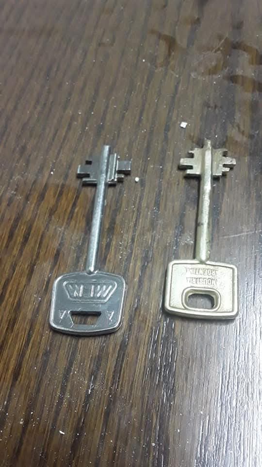 Dos llaves de caja fuerte, original y duplicado, sobre superficie de madera