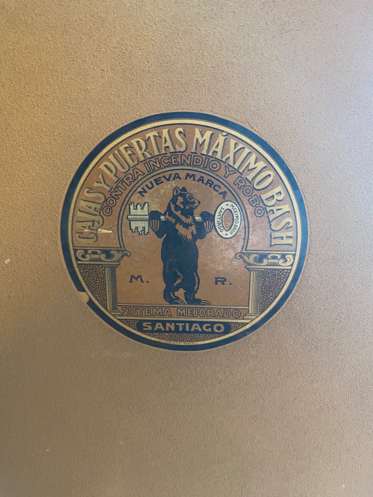 Medallón de bronce de la marca Máximo Bash en la puerta de la caja fuerte